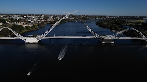 A modern bridge spanning a wide river with vehicles crossing.