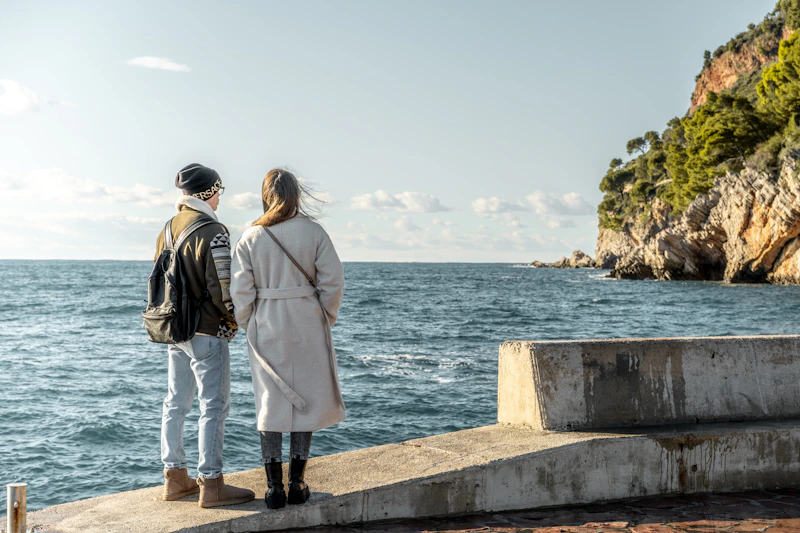 people standing together on pier overlooking water
