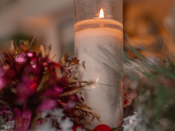 Warmly lit tabletop display featuring timeless Christmas ornaments and candles.