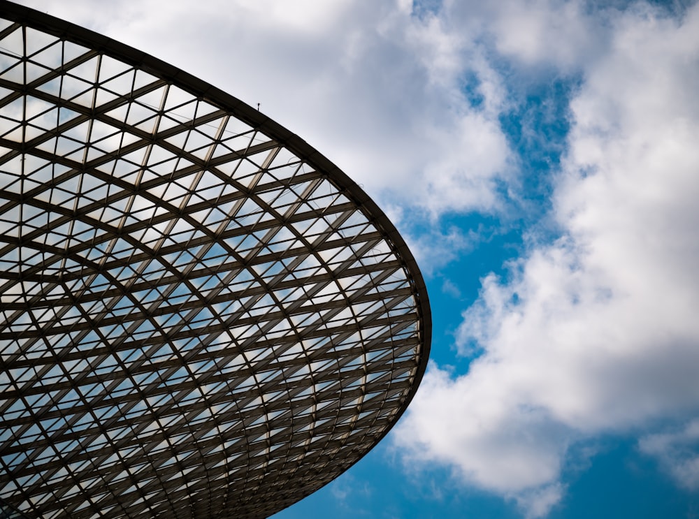 a large metal structure under a cloudy blue sky