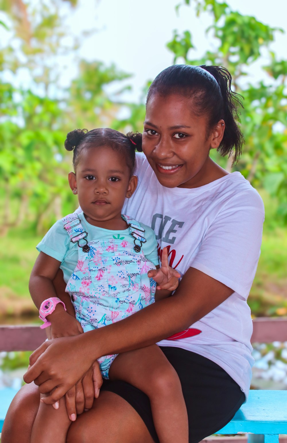 a woman sitting on a bench holding a small child