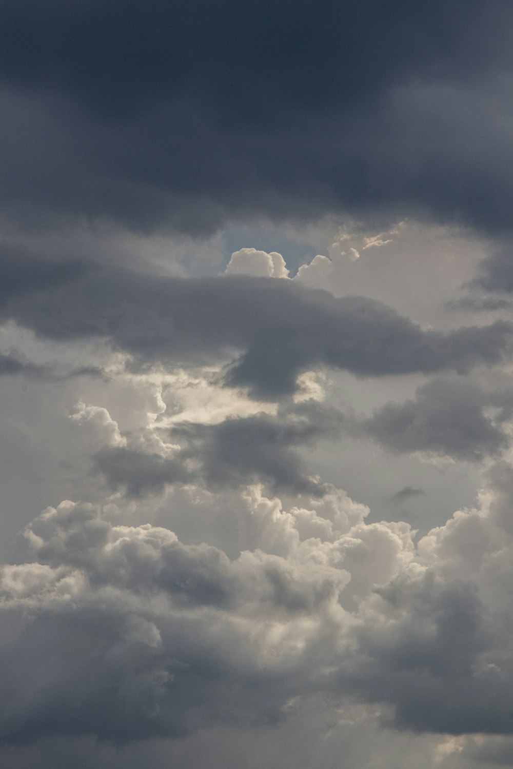 a plane flying through a cloudy sky on a cloudy day