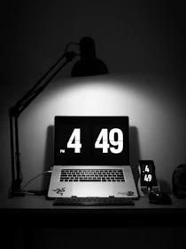 A business owner happily working on a laptop with a clock showing saved time.