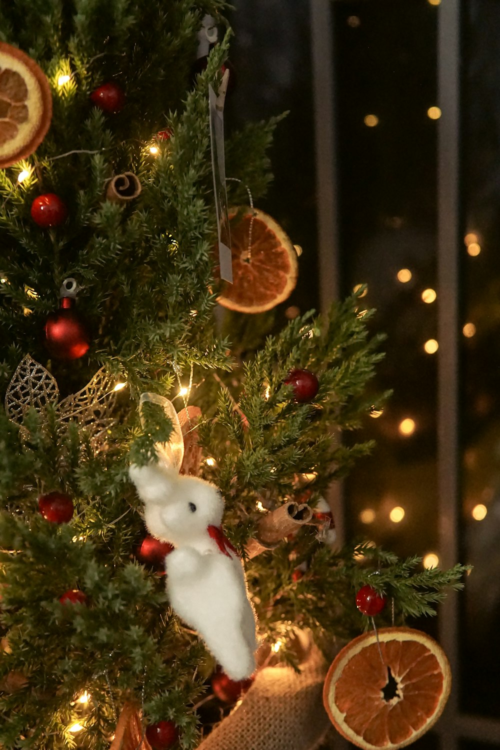 a christmas tree decorated with oranges and a white rabbit ornament