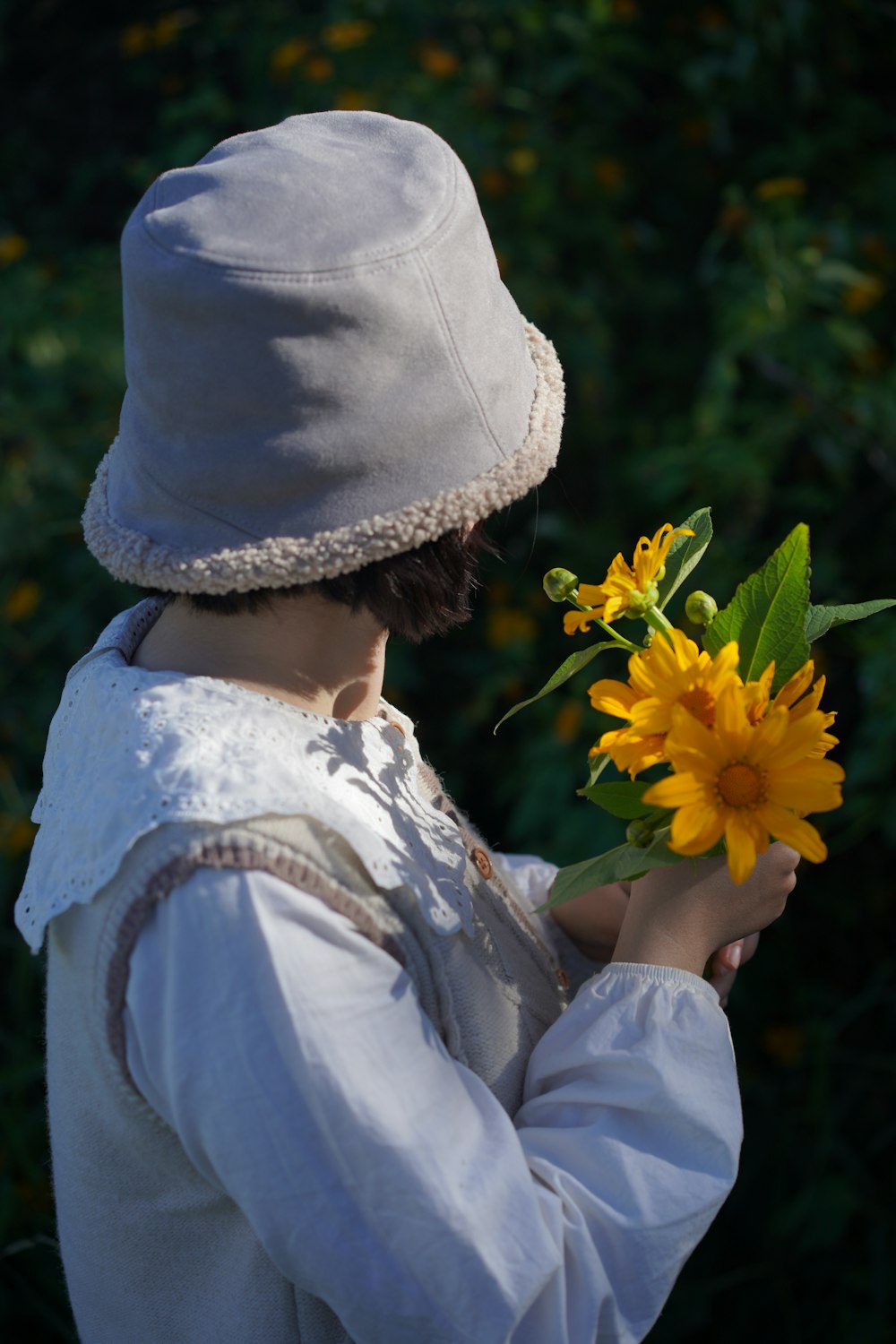 a woman in a white dress holding a yellow flower