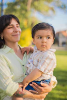 A candid shot of a mother walking outdoors holding her toddler’s hand.