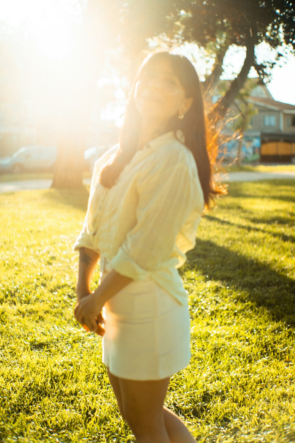 a woman in a white dress standing in the grass