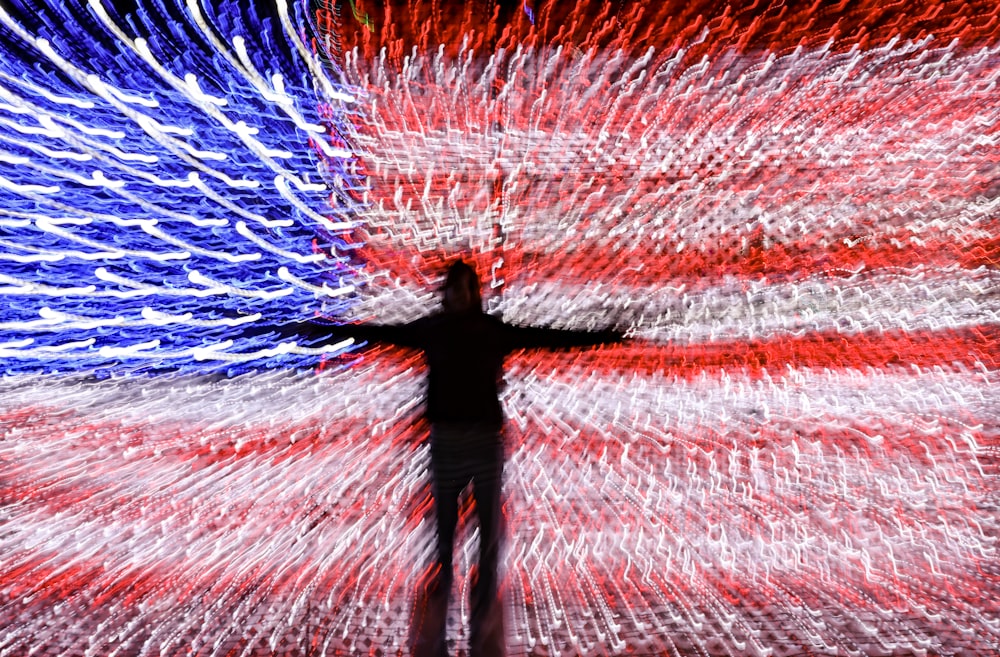 a man standing in front of an american flag