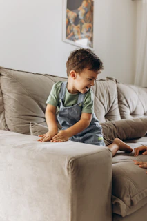 a little boy sitting on top of a couch next to a woman