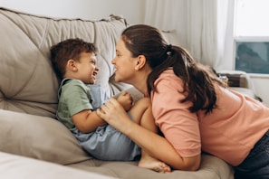 A playful moment of Silvia with her child in the living room, toys scattered around.