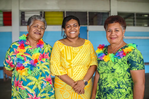 Family members of the concierge team smiling in 70s inspired outfits against a seaside backdrop.