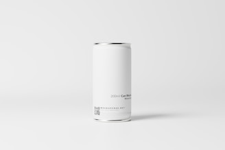 A plain white aluminum can is placed against a minimalistic, light gray background. The can has a sleek and smooth surface with text indicating a capacity of 200ml, and includes a small QR code and website information near the bottom.