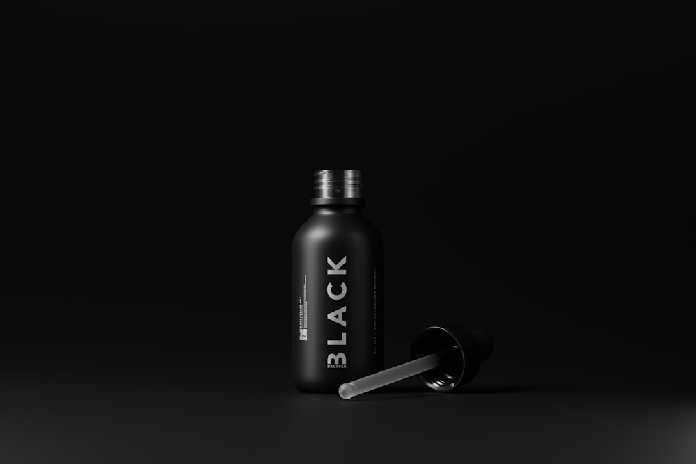 a black bottle with a black lid and a silver cap