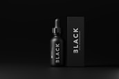 A minimalistic design featuring a black dropper bottle and a matching rectangular box both labeled with the word 'BLACK'. The overall aesthetic is sleek and modern, with smooth matte textures and white text contrasting against the dark background.