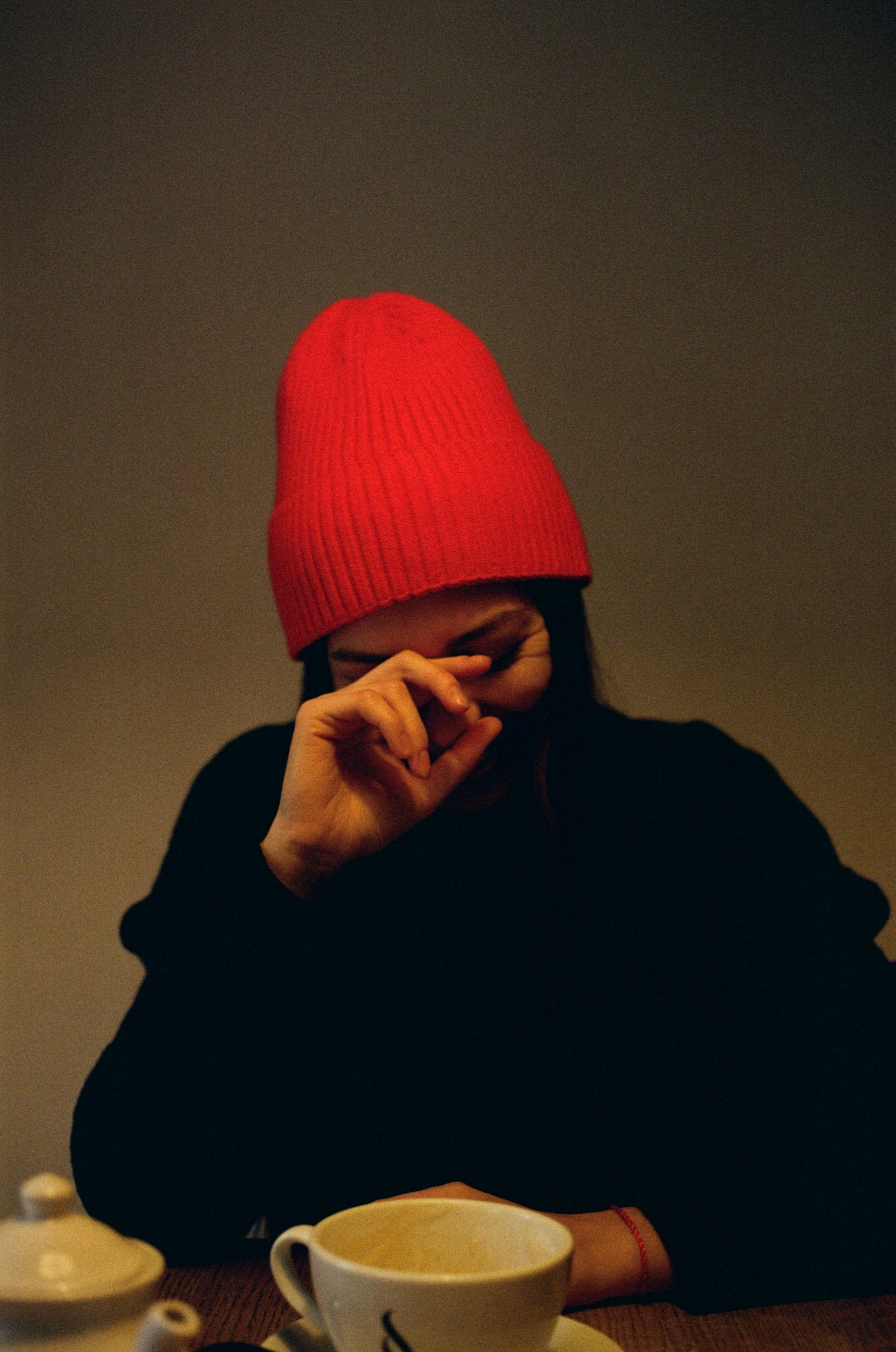 a woman sitting at a table with a cup of coffee