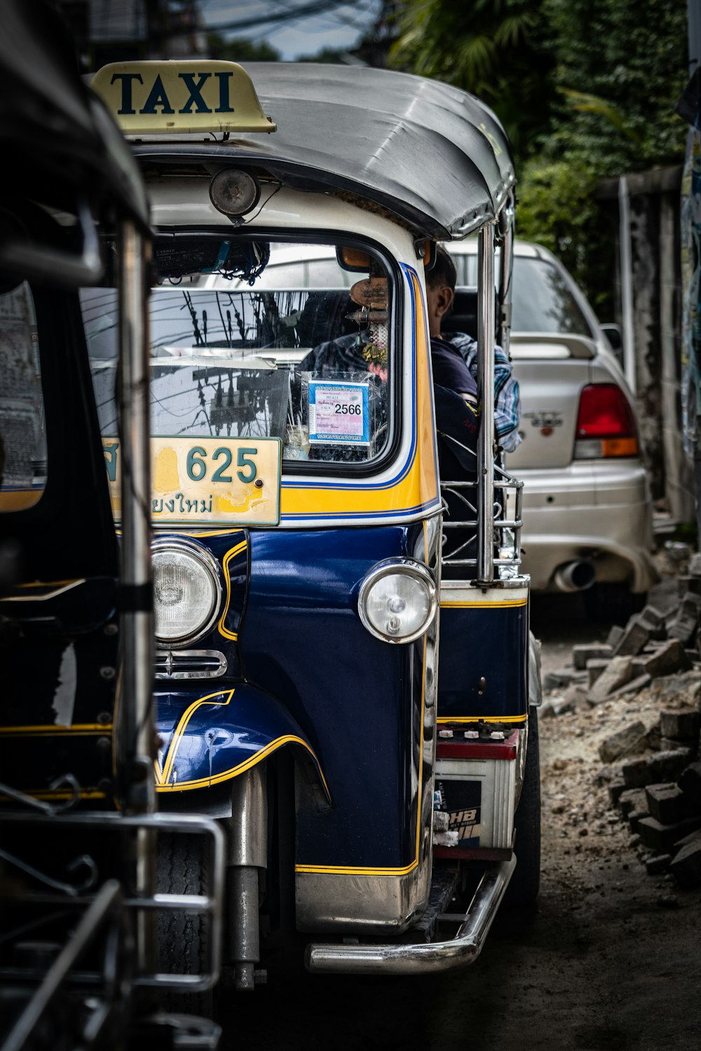 a blue and yellow taxi driving down a street