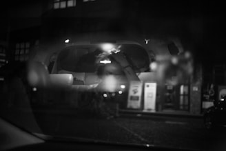 Still from a grainy black and white film showing a city street at night.