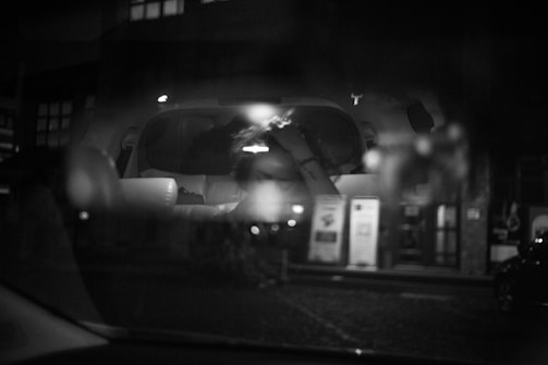 Still from a grainy black and white film showing a city street at night.