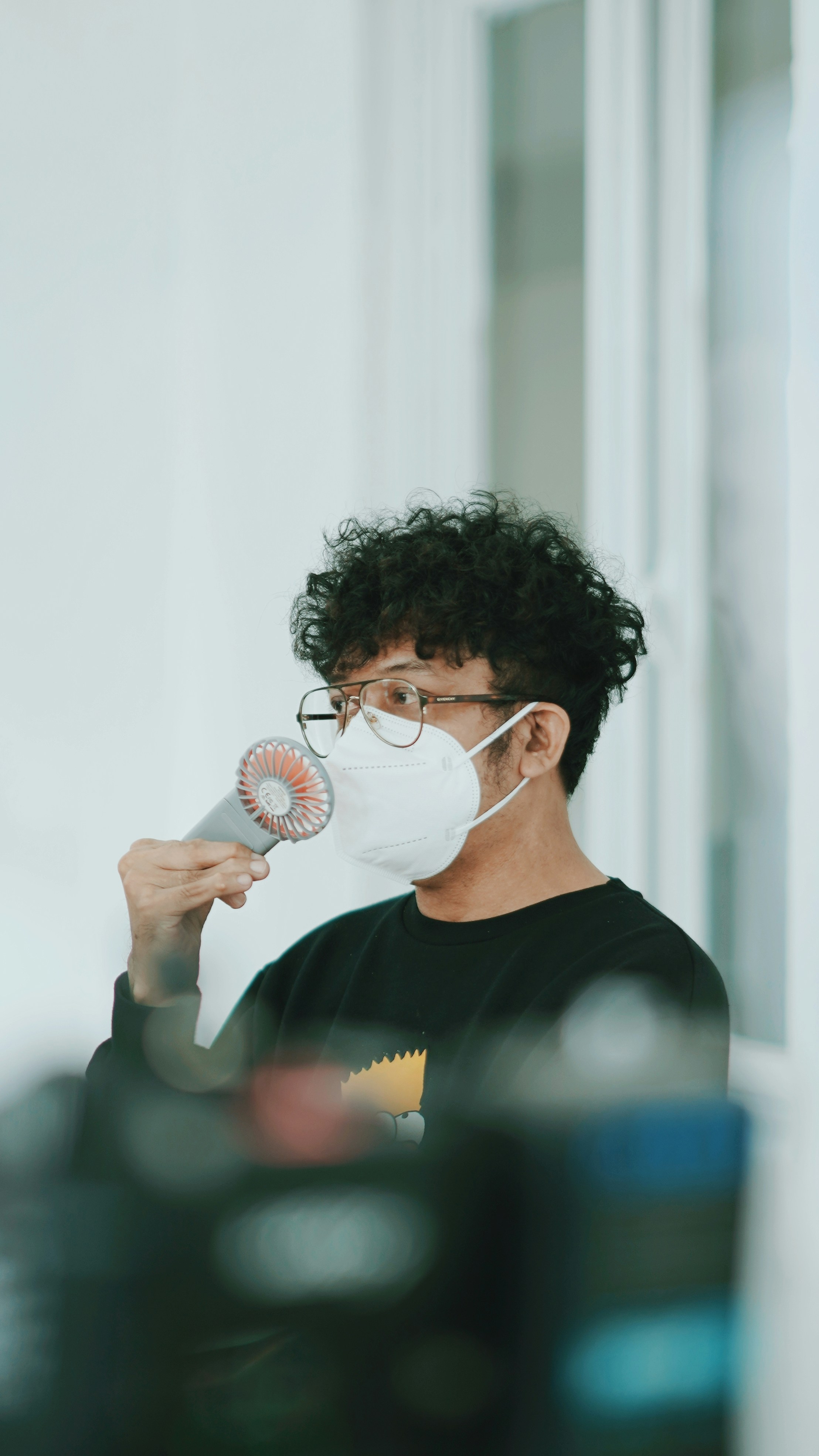 A man wearing a face mask and holding a hair dryer photo Free Person Image on Unsplash
