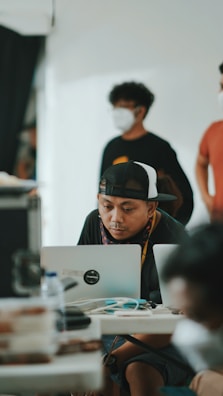 a man sitting at a table using a laptop computer