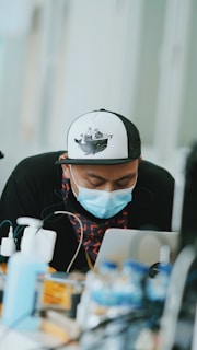 A focused student engaging with Marex Academy's maritime training on a laptop, surrounded by nautical charts and a model ship.