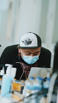 A focused student engaging with Marex Academy's maritime training on a laptop, surrounded by nautical charts and a model ship.