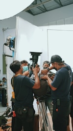 a group of men standing around a camera