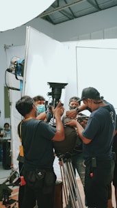 a group of men standing around a camera