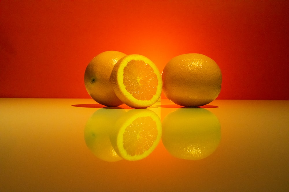 drei Orangen sitzen nebeneinander auf einem Tisch