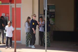 Customers using the ATM in a busy retail environment.