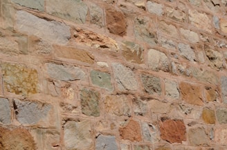 Outdoor stone wall made from sandstone blocks with warm earthy tones.