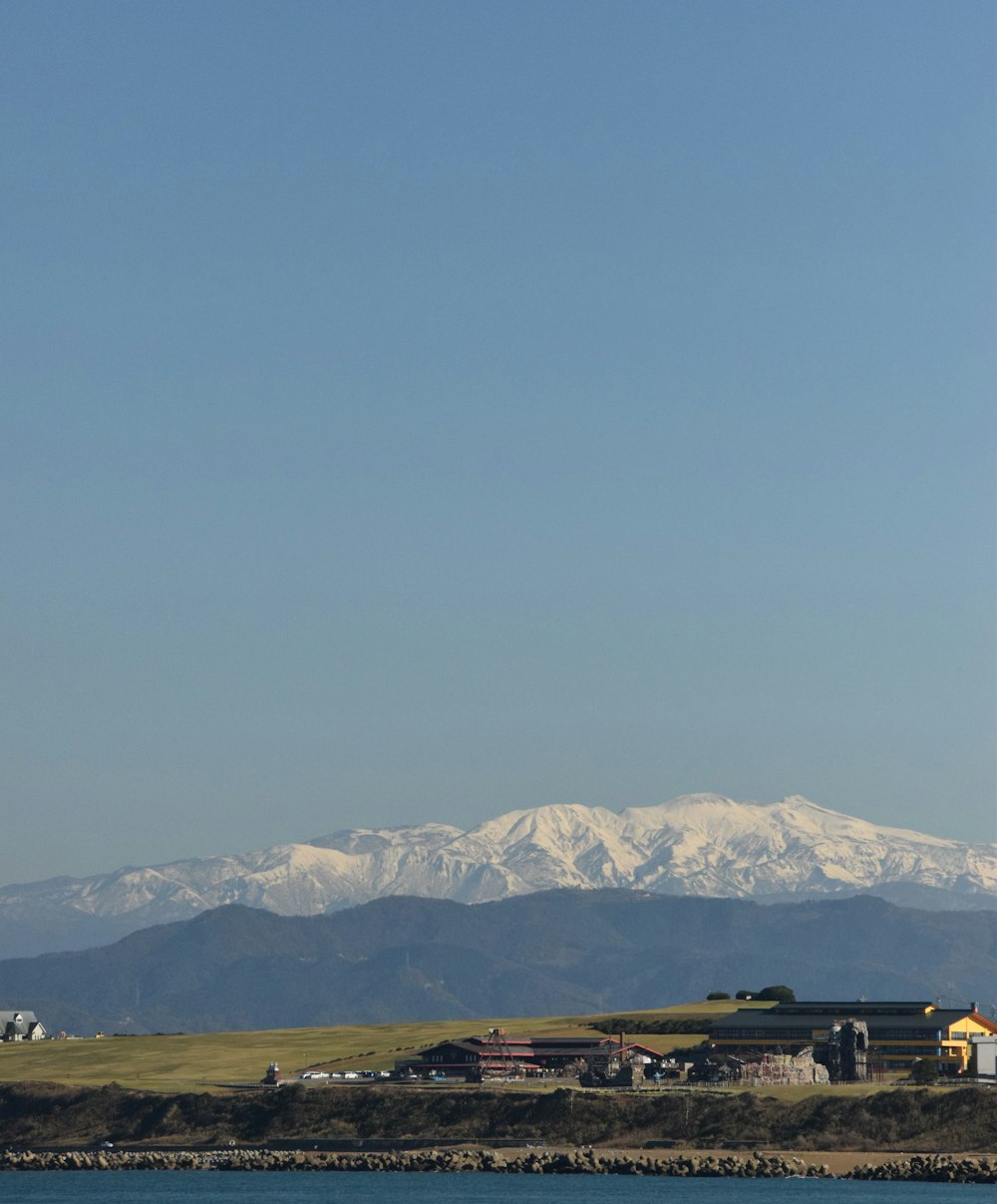 a plane flying over a body of water with mountains in the background