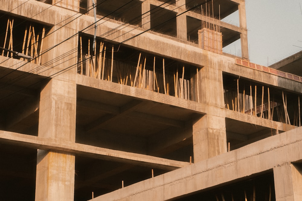 a building under construction with lots of wooden sticks sticking out of it