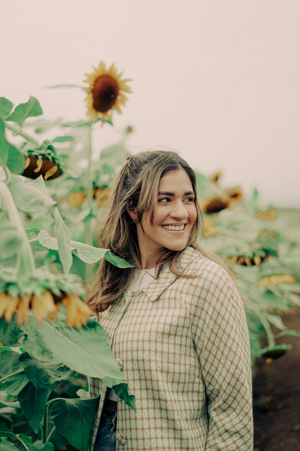 a woman standing in a field of sunflowers