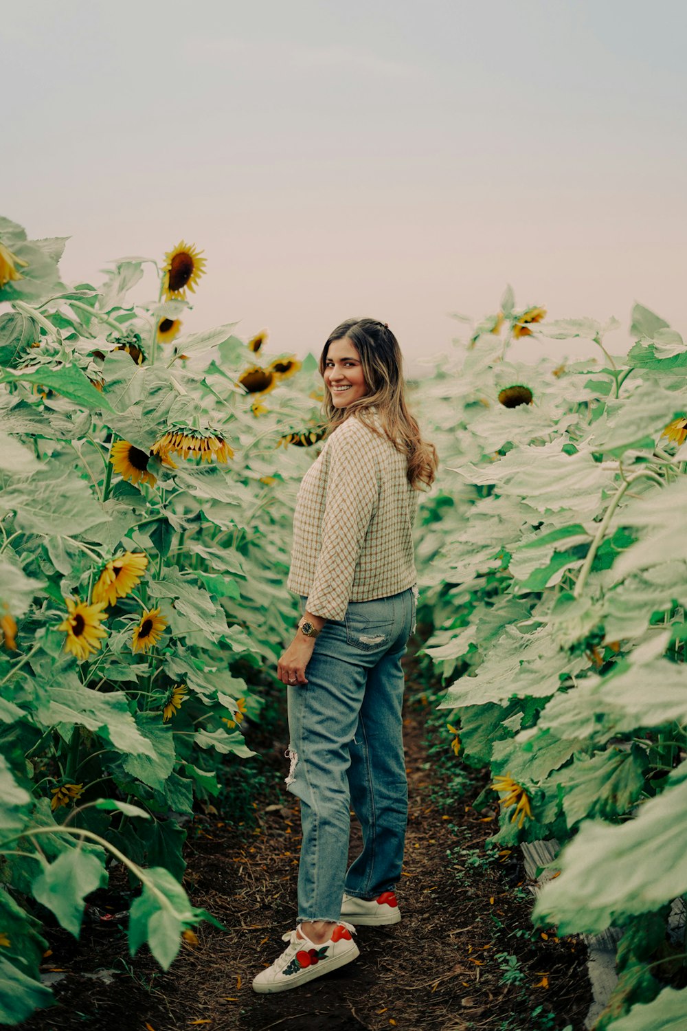 a woman standing in a field of sunflowers