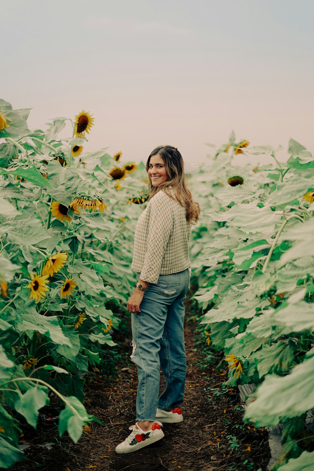 una mujer de pie en un campo de girasoles