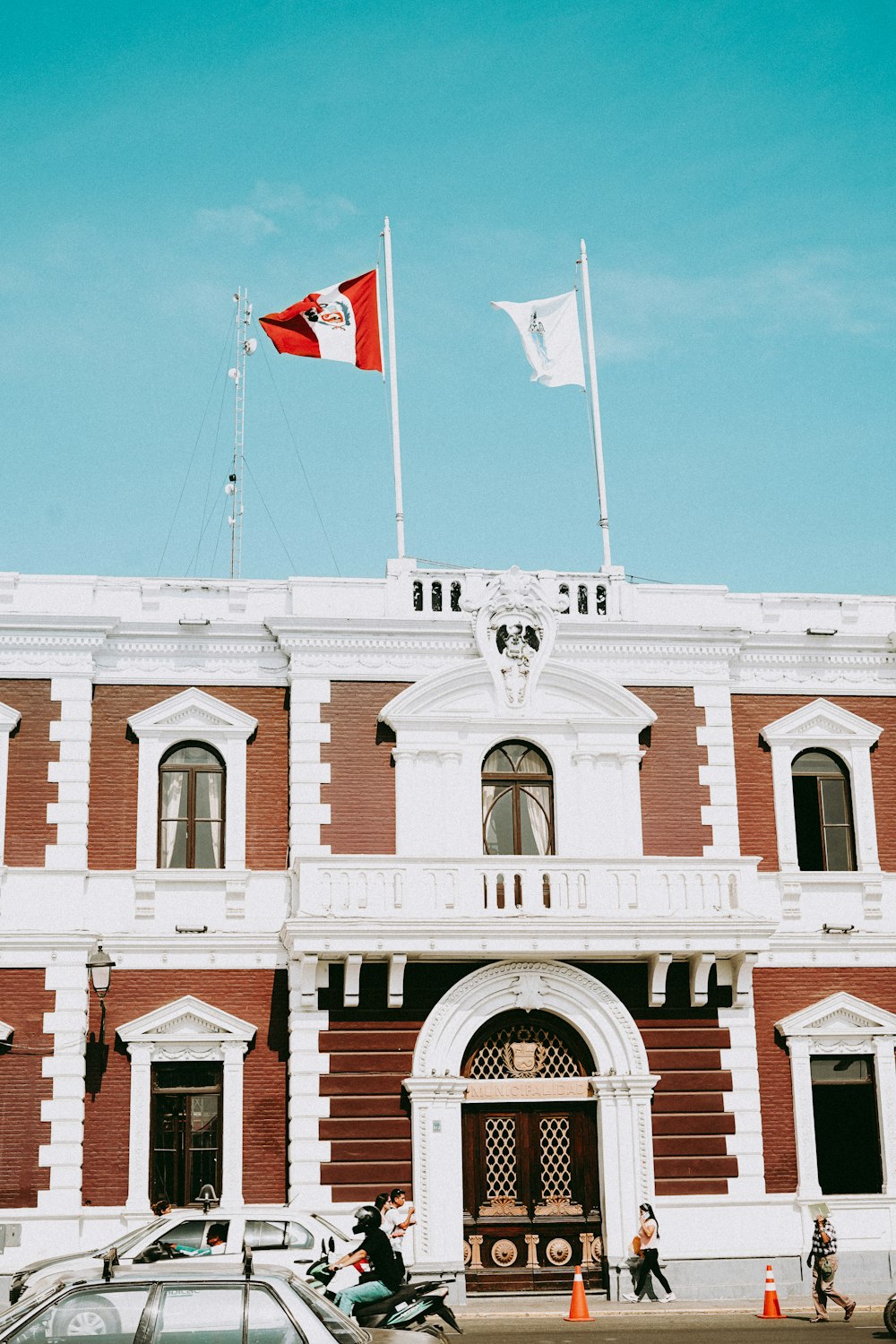 un gran edificio con una bandera en la parte superior