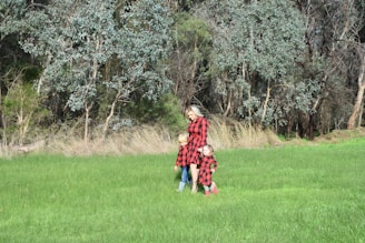 A family bundled up in classic plaid scarves, smiling on a crisp fall day in the park.