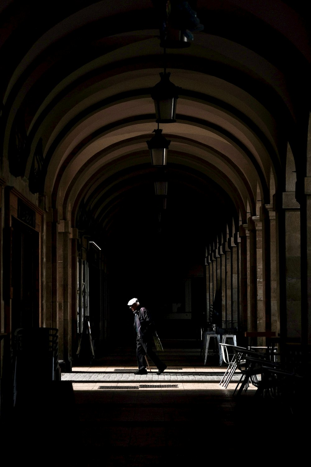 a person walking down a hallway with an umbrella