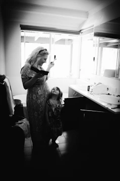 A cozy morning scene with a mom and child using natural skincare products in a sunlit bathroom