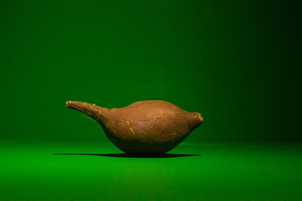 a single piece of fruit sitting on a green surface