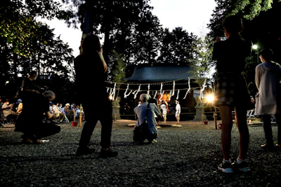 A warm gathering of diverse community members sharing stories outdoors at dusk.