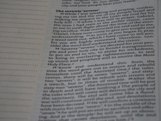 Close-up view of a page from a book featuring religious text. The page is open to a section titled 'The Seventy 'Sevens''. The text appears to discuss a vision and prophecy given by an angel named Gabriel, making references to 'seventy sevens' and religious concepts such as understanding, vision, and righteousness. The text is laid out in paragraph form with a clear font for readability.