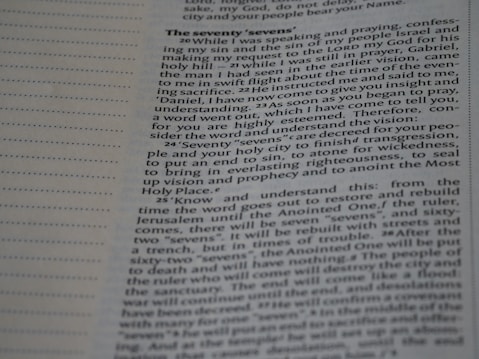 Close-up view of a page from a book featuring religious text. The page is open to a section titled 'The Seventy 'Sevens''. The text appears to discuss a vision and prophecy given by an angel named Gabriel, making references to 'seventy sevens' and religious concepts such as understanding, vision, and righteousness. The text is laid out in paragraph form with a clear font for readability.
