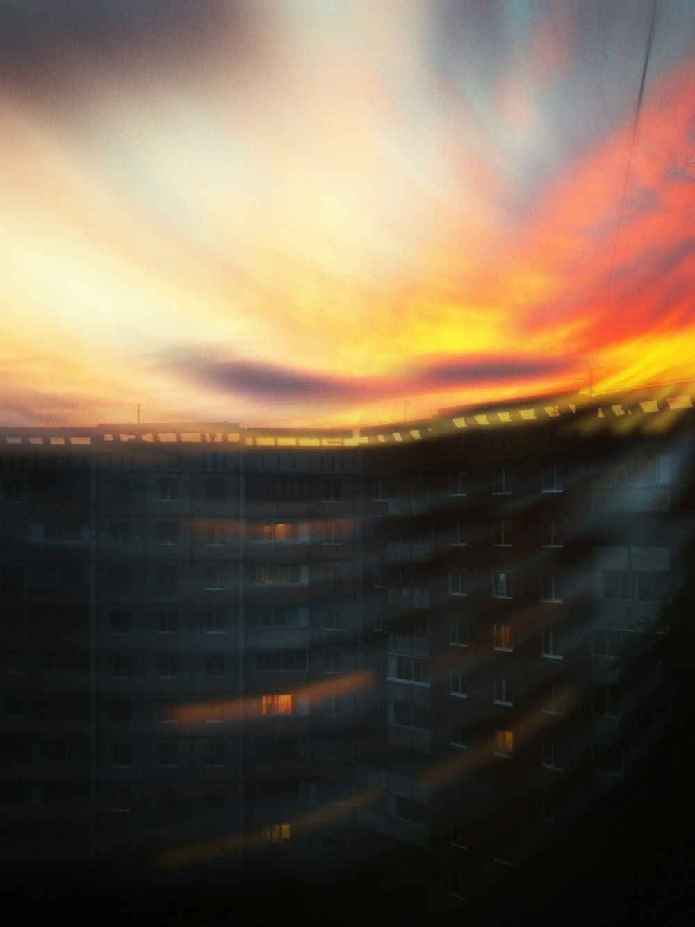 a blurry photo of a building with a sunset in the background