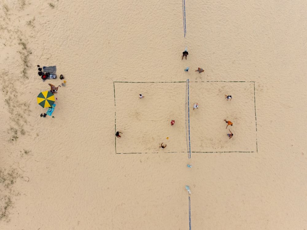 a group of people standing on top of a sandy beach