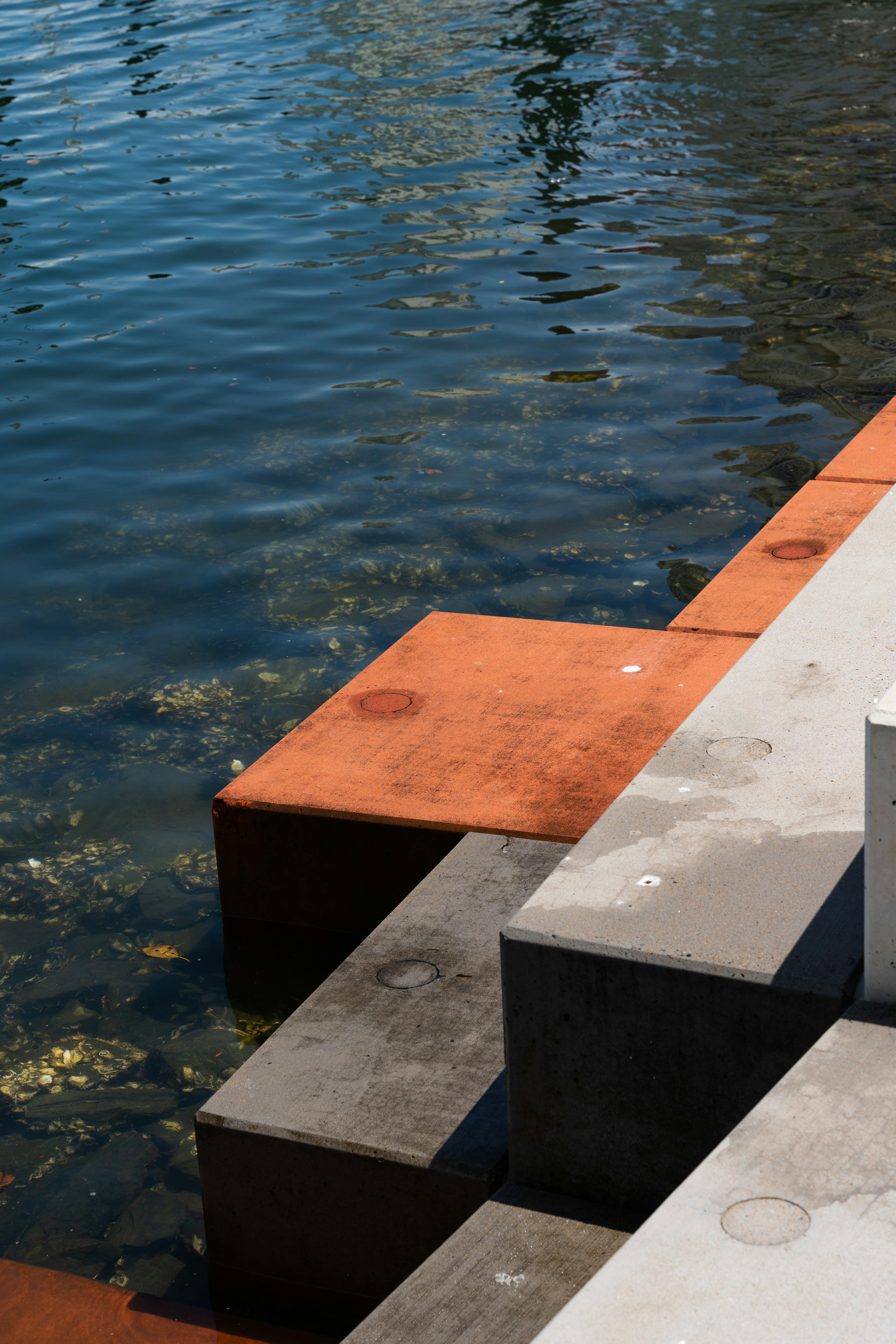 un quai en béton surmonté d’une bouée rouge et blanche ;