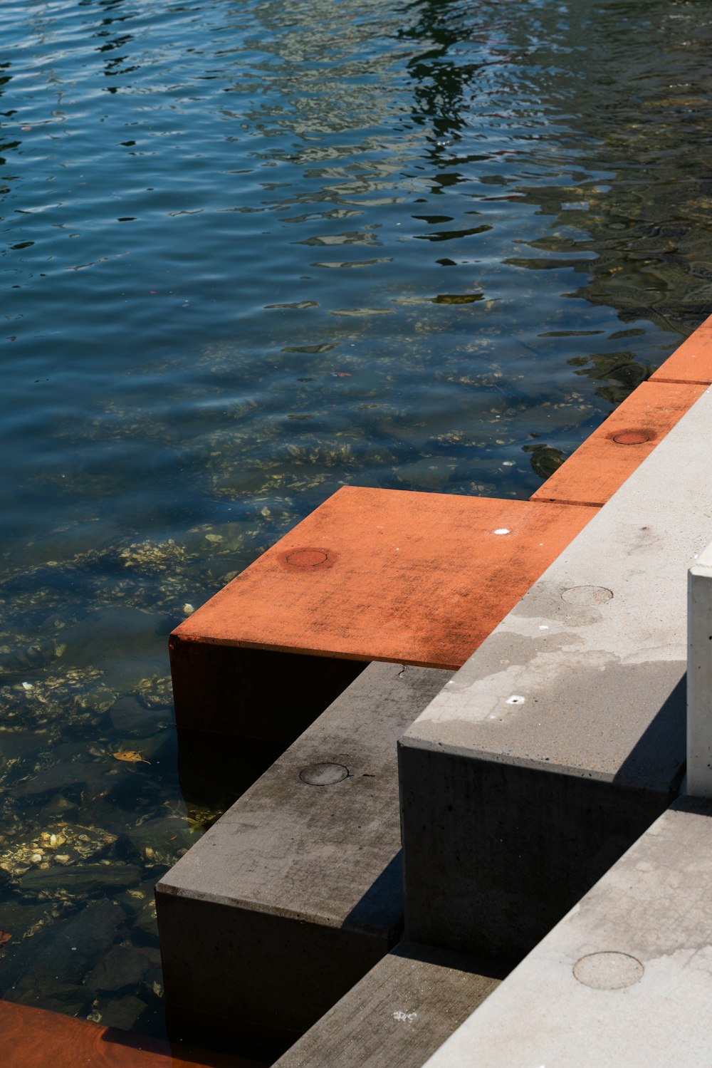 a concrete dock with a red and white buoy sitting on top of it