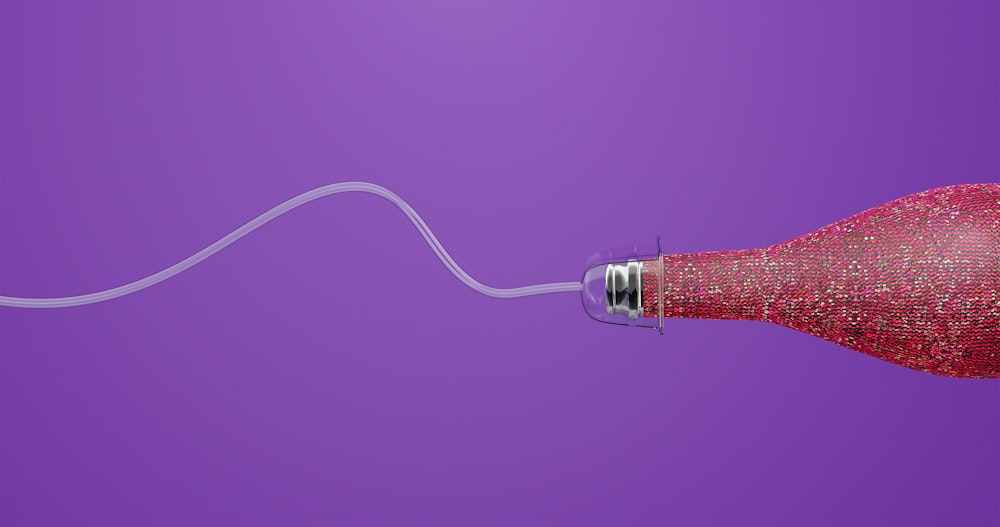 a close up of a red object on a purple background