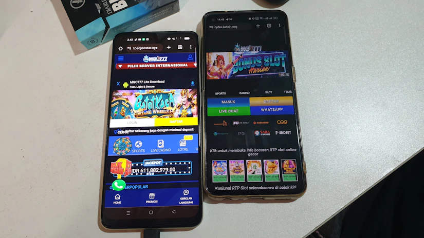 Two smartphones are displayed on a white surface, both showing gambling websites with colorful graphics, text, and various options for logging in and accessing games. The screens are bright and filled with promotional content related to casino and slot games.